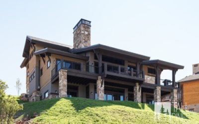 Luxury mountain home exterior with stone and wood finishes and expansive balconies