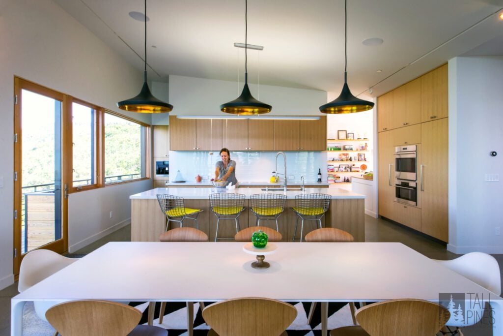 In this charming kitchen, we incorporated cheerful whites, timeless wood, and a bit of personality with the bar stools. This kitchen island works hard with the in-island sink and dishwasher, plenty of seating for little ones and guests, and so much functional storage. 