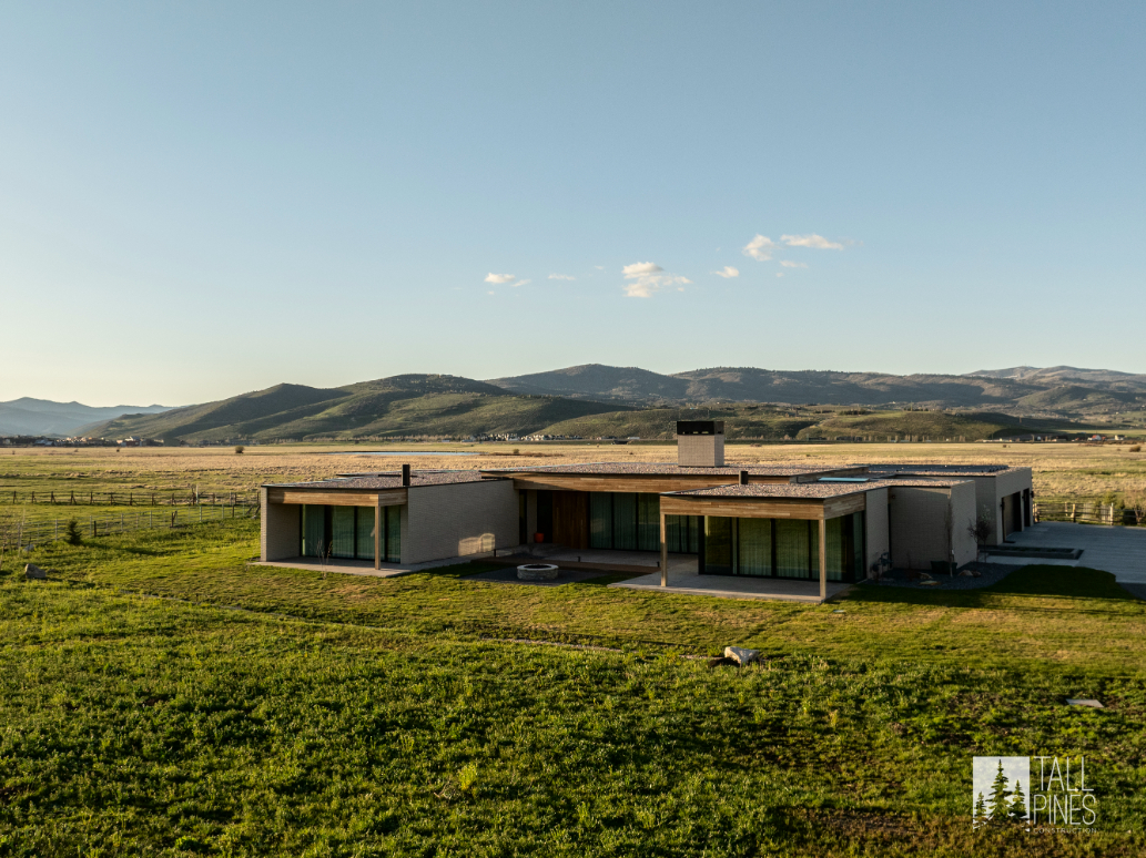 Elegant modern mountain home in Park City, Utah, with clean lines, glass walls, and open landscape.