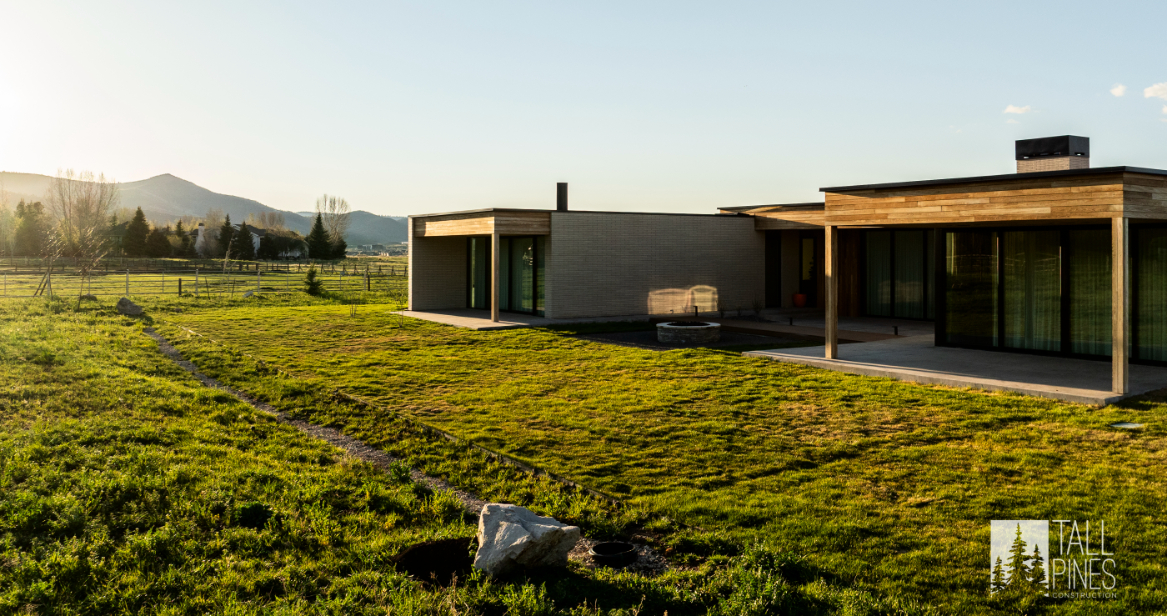 Side view of a modern home in Park City during golden hour with mountains in the background.