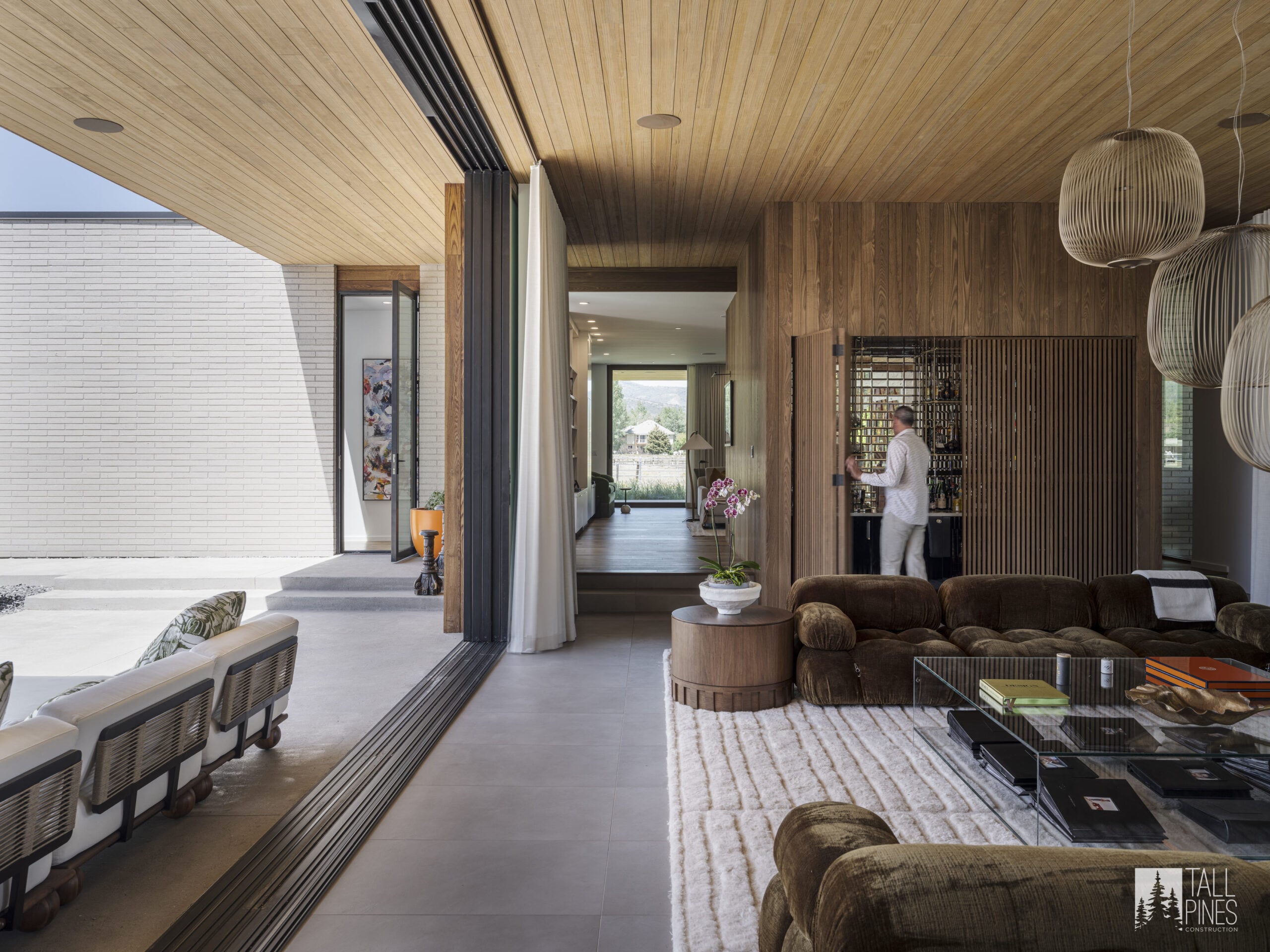 A luxury living room with a retractable glass wall for a Park City custom home builder project by Tall Pines Construction in Park City, Utah.