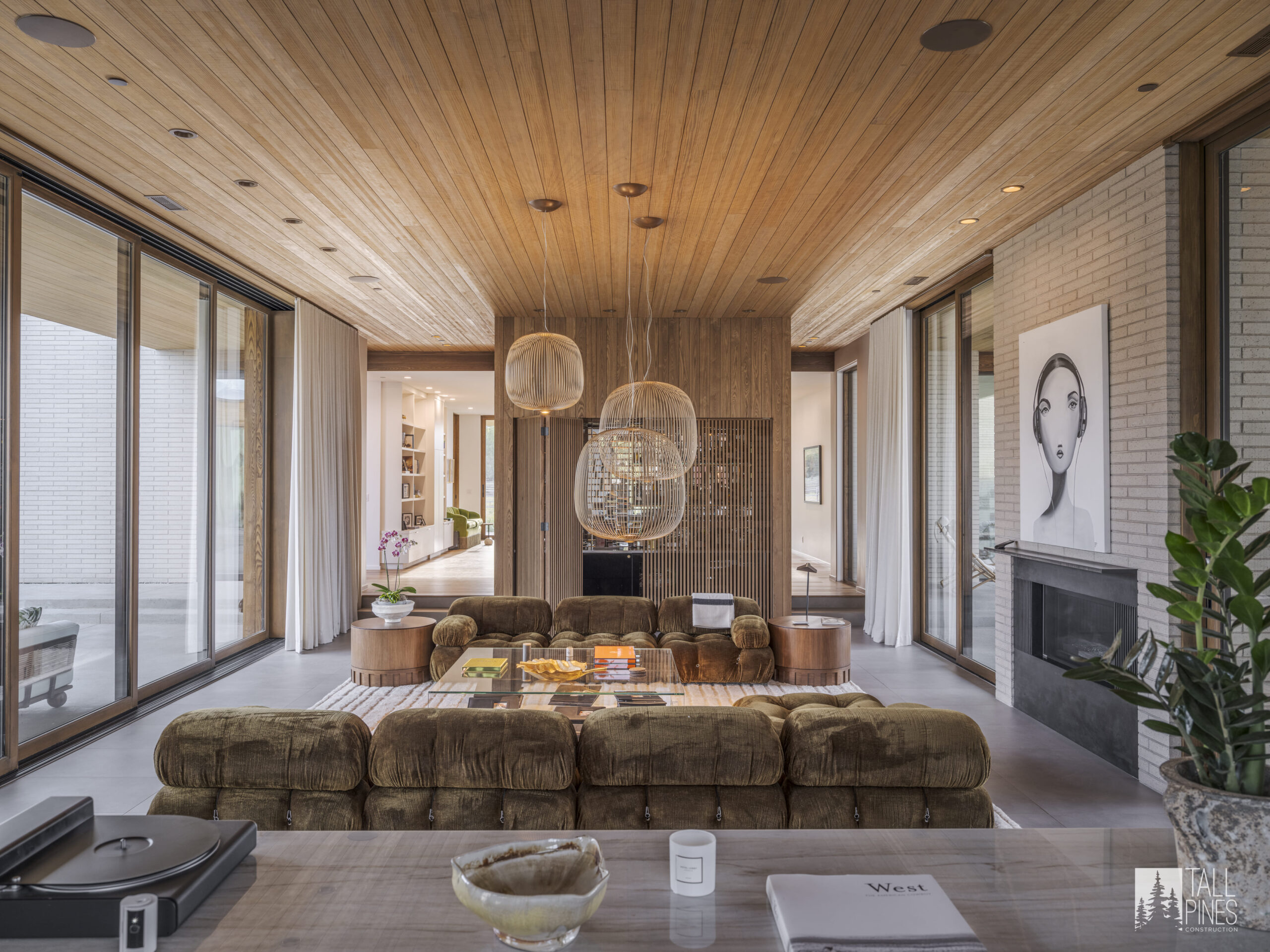 A spacious living room with wood ceilings and modern lighting for a Park City home builder project by Tall Pines Construction in Park City, Utah.