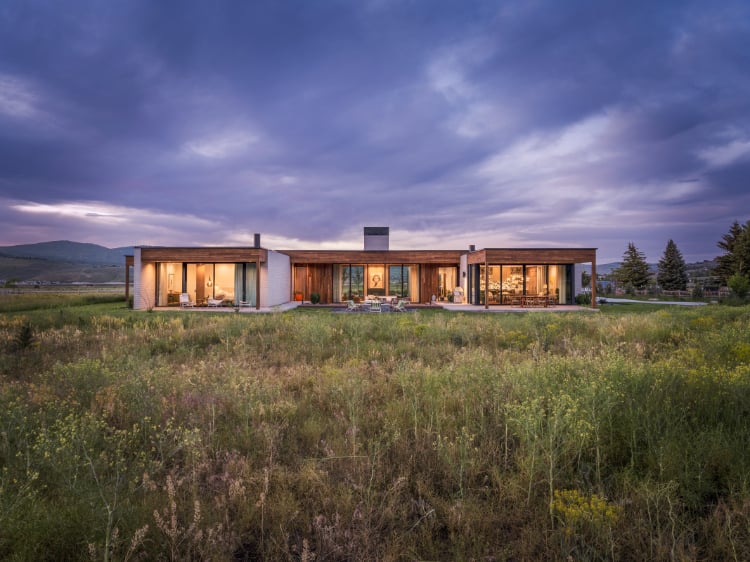 A modern ranch-style custom home set against open Utah landscape, featuring expansive glass, clean lines, and intentional exterior design by Tall Pines Construction.