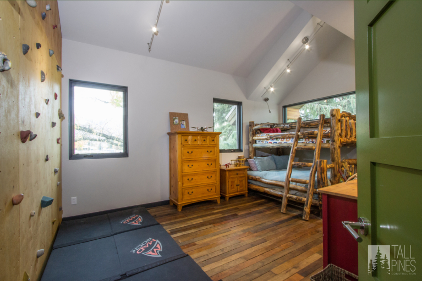 This kids' room inspiration features freestanding rustic log bunk beds for a mountain-cabin feel and a built-in rock wall for hours of entertainment and fun.
