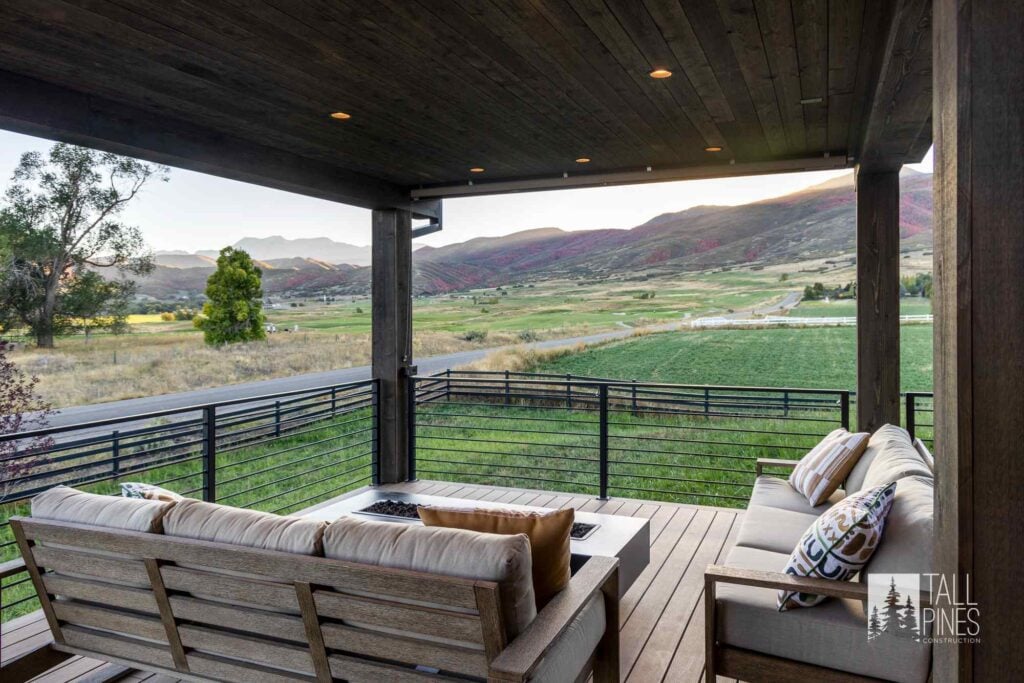 Covered outdoor living area with comfortable seating and panoramic mountain views at a Park City custom home.
