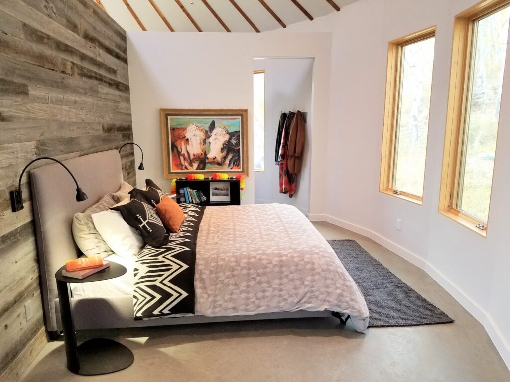 Modern bedroom inside a Park City yurt featuring warm wood accents, natural light, and refined mountain home design.