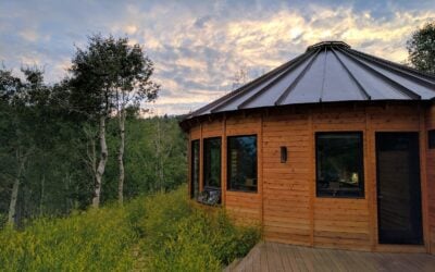 Exterior of a custom Park City yurt at dusk featuring contemporary architecture, natural cedar siding, and a peaceful mountain setting.