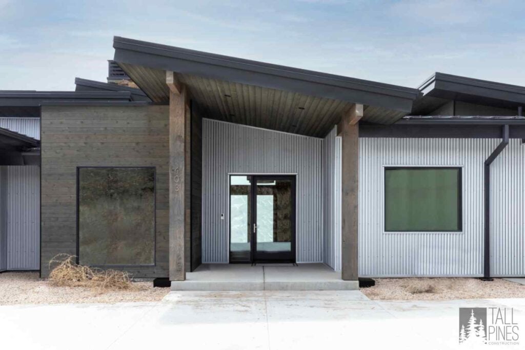 Contemporary Park City home exterior combining wood, metal siding, large windows, and durable materials for sustainable mountain living.
