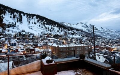 Snow-covered Park City and surrounding ski slopes viewed from the outdoor living area of a custom mountain home.