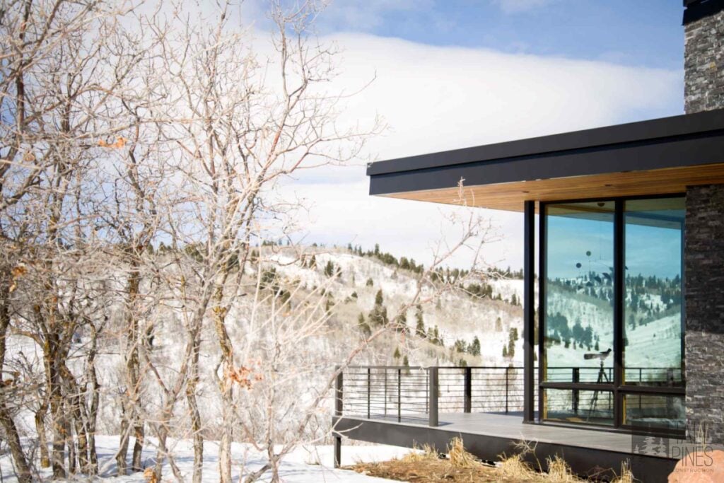 Modern luxury residence in Park City surrounded by snow-covered mountain terrain and designed with expansive windows and natural materials.