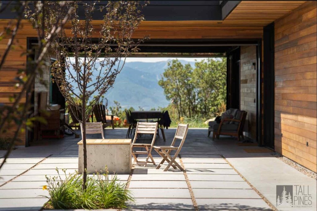 Covered outdoor living space of a modern Park City home featuring natural wood siding, mountain views, and seamless indoor-outdoor design.