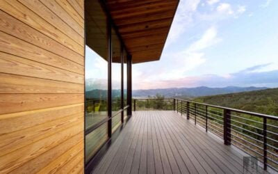 Expansive deck on a sustainable Park City mountain home featuring wood siding, large windows, and views of the surrounding landscape.