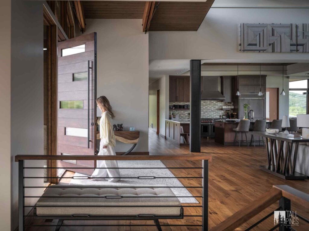 Modern mountain home entry and kitchen featuring natural wood floors, contemporary finishes, and open living spaces.