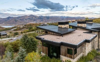 Mountain modern home in Park City featuring stone, natural wood, metal rooflines, and views of the surrounding mountains.