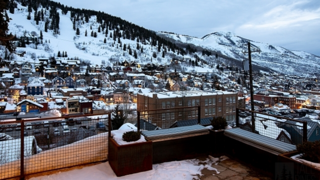 Snow-covered Park City and surrounding ski slopes viewed from the outdoor living area of a custom mountain home.