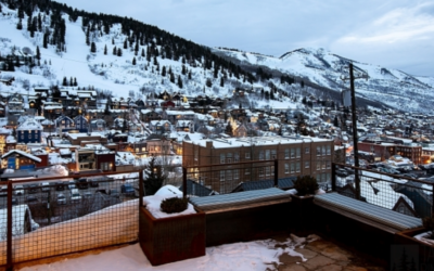 Snow-covered Park City and surrounding ski slopes viewed from the outdoor living area of a custom mountain home.