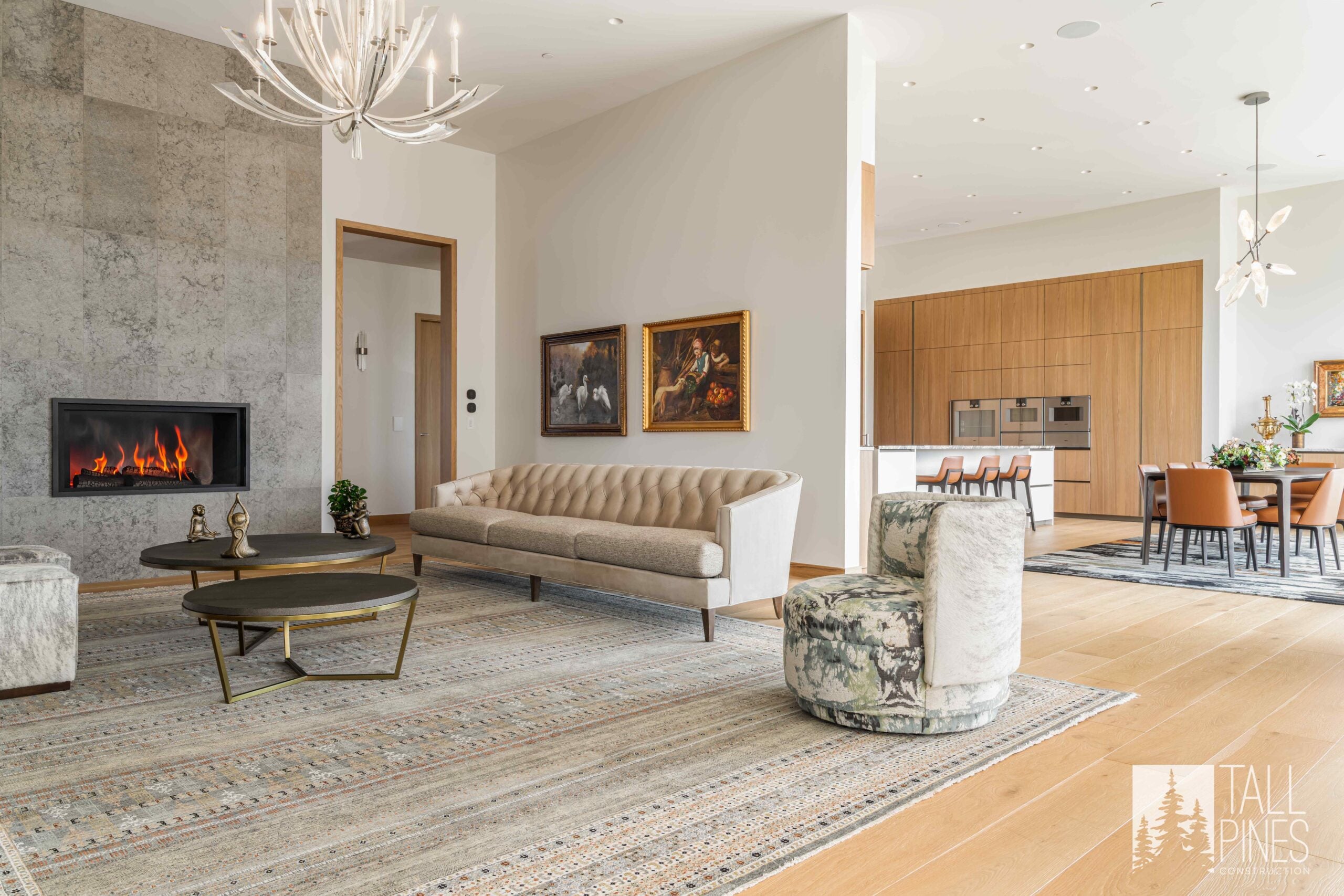 Bright open living room at Ridgeline Light featuring a modern fireplace, light wood floors and an adjoining kitchen and dining area.